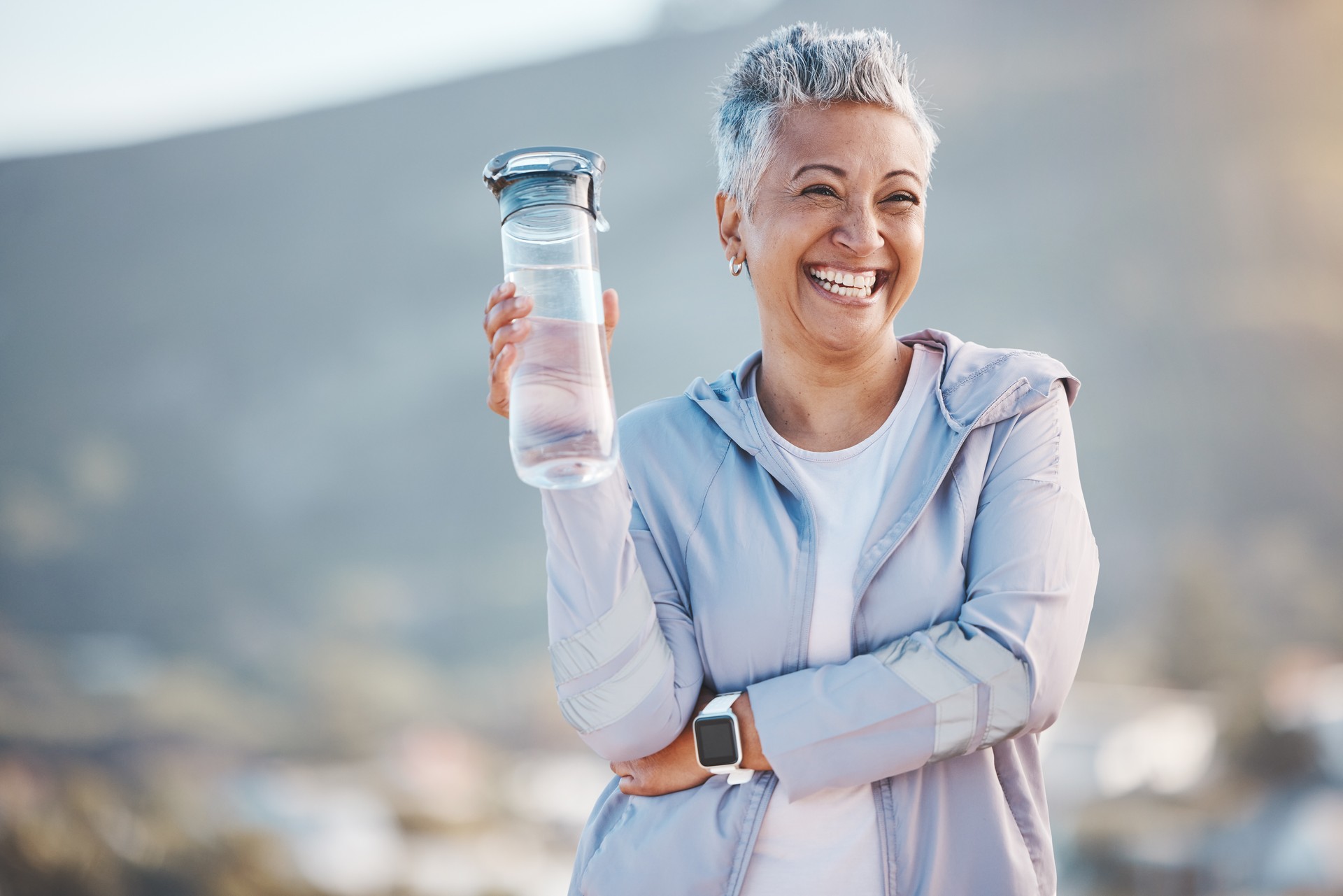 Fitness, happy or old woman with water bottle in nature to start training, exercise or hiking workout in New Zealand. Portrait, liquid or healthy senior person smiles with pride, goals or motivation