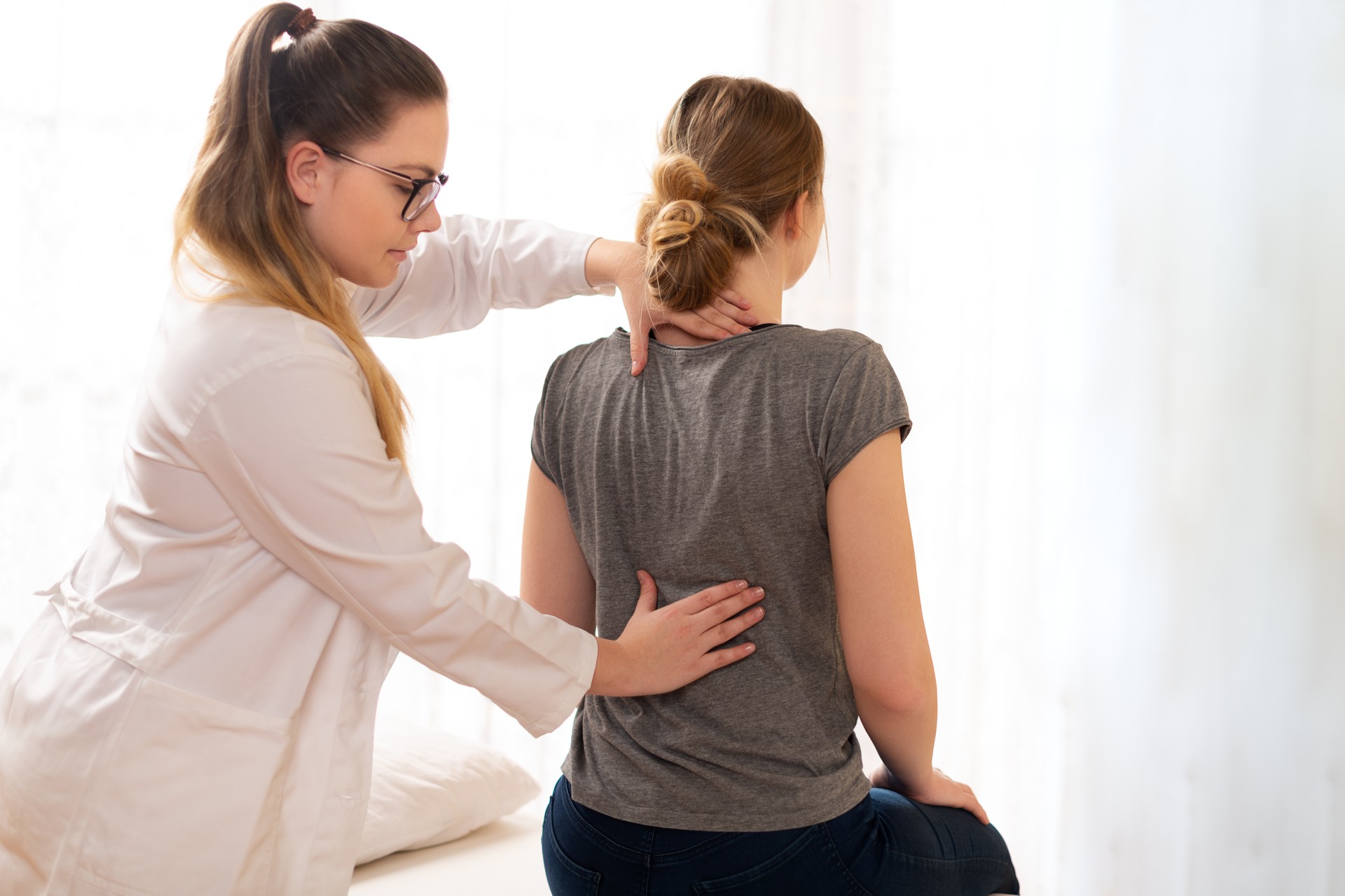 Female chiropractor examining patients back. Spinal Decompression. 